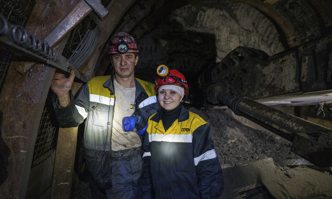 DTEK miners standing side by side inside an underground tunnel